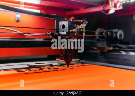 flying head of a laser cutting machine while cutting technological holes in plywood Stock Photo