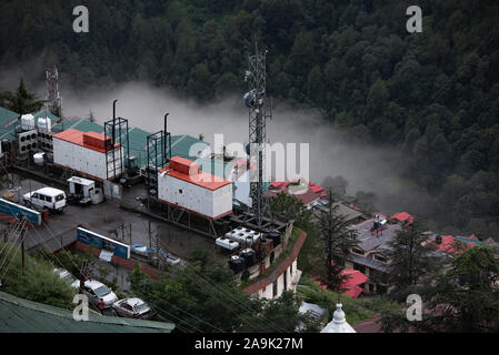 Buildings, mobile masts, telegraph poles on the misty mountains during monsoon season in the Himalayas. Hills around Shimla, Himachal Pradesh, India Stock Photo