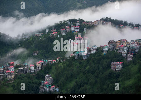 Buildings dotted on the misty mountains during the monsoon season in the Himalayas. Hills around Shimla, Himachal Pradesh, India Stock Photo