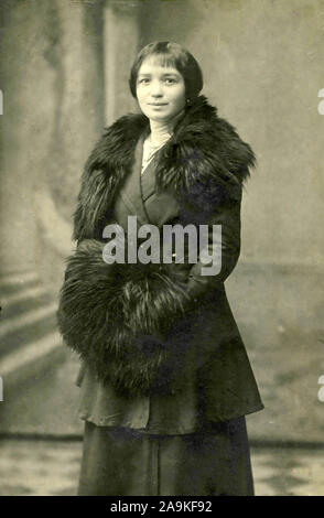 Portrait of woman in black dress and fur handwarmer, Italy Stock Photo