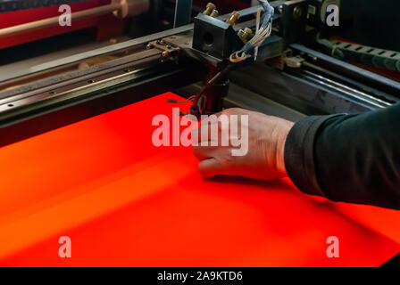 master manually adjusts the flying head of the laser cutting machine before starting work Stock Photo