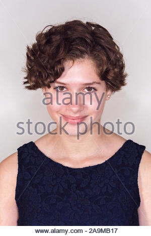 Teenage Girl With Short Brown Curly Hair Models Fashions In Studio
