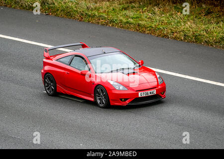 2006 red Toyota Celica Vvtl-I GT; UK Vehicular traffic, transport, modern vehicles, saloon cars, south-bound on the 3 lane M61 motorway highway. Stock Photo