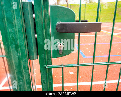 Internal lock with a handle on an iron street gate. Place for text. Stock Photo