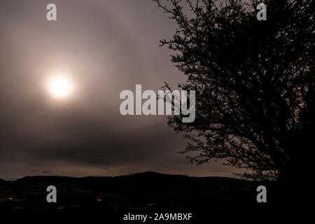 Full moon shining through clouds over the Clwydian Range AONB, North Wales Stock Photo