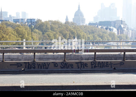 this way to save the planet, graffiti on a barrier on Waterloo bridge for the Extinction Rebellion protest in London Stock Photo
