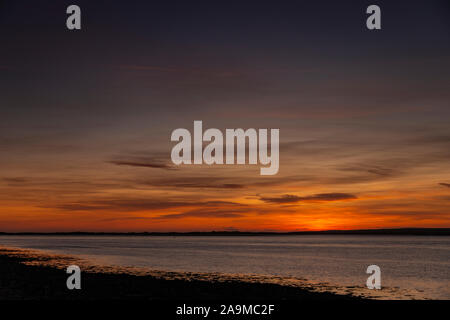 Sunset over the Menai Straits from Caernarfon on the North Wales coast Stock Photo