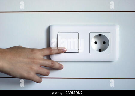 Hand pressing the white light button. Turning off/on the bedroom light. White background. Stock Photo