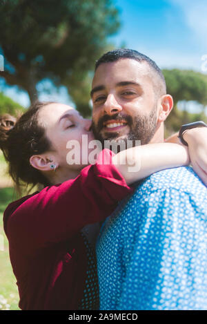 Happy couple kissing and hugging in the park Stock Photo