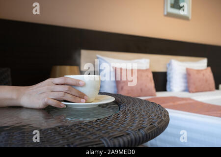 Close up of a woman hands holding a hot coffee cup in the hotel, Morning time. Stock Photo
