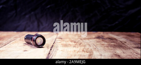 Small pocket LED torch isolated on wooden table Stock Photo