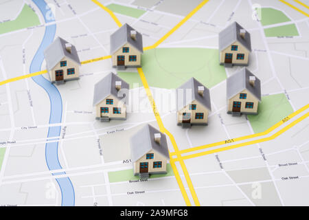 High Angle View Of Small House Models Over Road Route Map Stock Photo