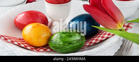 Easter Decoration Breakfast Table Red Tulips with red Easter Eggs as Background Stock Photo