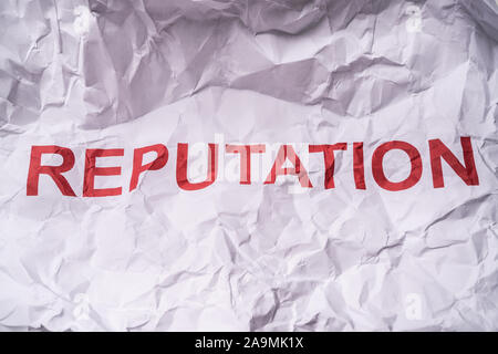Close-up Of A Reputation Word Over White Paper With Creased Stock Photo