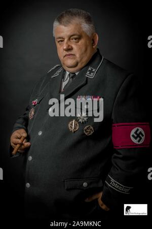 man wearing gestapo uniform smoking a cigar Stock Photo