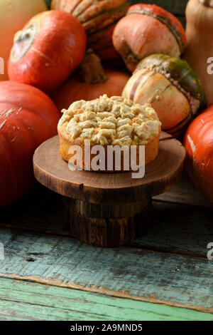 Homemade pastry concept. Pumpkin cake and orange winter squashes on wood slabs on green shabby background side view copy space Stock Photo