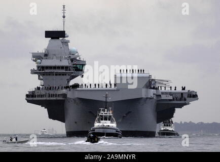 AJAXNETPHOTO. 16TH AUGUST, 2017. PORTSMOUTH, ENGLAND. - ROYAL NAVY'S BIGGEST WARSHIP SAILS INTO HOME PORT - HMS QUEEN ELIZABTH, THE FIRST OF TWO 65,000 TONNE, 900 FT LONG, STATE-OF-THE-ART AIRCRAFT CARRIERS SAILED INTO PORTSMOUTH NAVAL BASE IN THE EARLY HOURS OF THIS MORNING, GENTLY PUSHED AND SHOVED BY SIX TUGS INTO HER NEW BERTH ON PRINCESS ROYAL JETTY. THE £3BN CARRIER, THE LARGEST WARSHIP EVER BUILT FOR THE ROYAL NAVY, ARRIVED AT ARRIVED AT HER HOME PORT TWO DAYS AHEAD OF HER ORIGINAL SCHEDULE.  PHOTO: JONATHAN EASTLAND/AJAX  REF: D171608 6769 Stock Photo