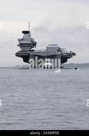 AJAXNETPHOTO. 16TH AUGUST, 2017. PORTSMOUTH, ENGLAND. - ROYAL NAVY'S BIGGEST WARSHIP SAILS INTO HOME PORT - HMS QUEEN ELIZABTH, THE FIRST OF TWO 65,000 TONNE, 900 FT LONG, STATE-OF-THE-ART AIRCRAFT CARRIERS SAILED INTO PORTSMOUTH NAVAL BASE IN THE EARLY HOURS OF THIS MORNING, GENTLY PUSHED AND SHOVED BY SIX TUGS INTO HER NEW BERTH ON PRINCESS ROYAL JETTY. THE £3BN CARRIER, THE LARGEST WARSHIP EVER BUILT FOR THE ROYAL NAVY, ARRIVED AT ARRIVED AT HER HOME PORT TWO DAYS AHEAD OF HER ORIGINAL SCHEDULE.  PHOTO: JONATHAN EASTLAND/AJAX  REF: D171608 6771 Stock Photo