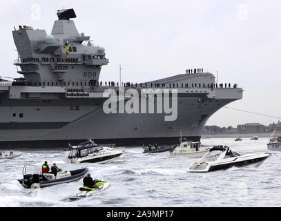AJAXNETPHOTO. 16TH AUGUST, 2017. PORTSMOUTH, ENGLAND. - ROYAL NAVY'S BIGGEST WARSHIP SAILS INTO HOME PORT - HMS QUEEN ELIZABTH, THE FIRST OF TWO 65,000 TONNE, 900 FT LONG, STATE-OF-THE-ART AIRCRAFT CARRIERS SAILED INTO PORTSMOUTH NAVAL BASE IN THE EARLY HOURS OF THIS MORNING, GENTLY PUSHED AND SHOVED BY SIX TUGS INTO HER NEW BERTH ON PRINCESS ROYAL JETTY. THE £3BN CARRIER, THE LARGEST WARSHIP EVER BUILT FOR THE ROYAL NAVY, ARRIVED AT ARRIVED AT HER HOME PORT TWO DAYS AHEAD OF HER ORIGINAL SCHEDULE.  PHOTO: JONATHAN EASTLAND/AJAX  REF: D171608 6785 Stock Photo