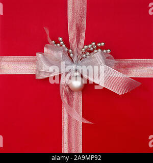 Close-up closeup of red Christmas gift present with metallic silver ribbon, bow and decorations. Beautiful, fancy, elegant Christmas gifts backgrounds Stock Photo