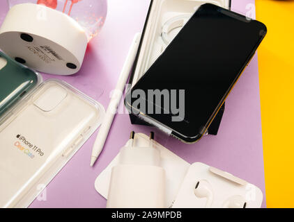 Paris, France - Sep 20, 2019: View from above of the plastic film protection on the display of latest iPhone 11 Pro by Apple Computers after unboxing on table with multiple objects Stock Photo