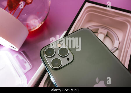 Paris, France - Sep 20, 2019: View from above of the cardboard box and accessories focus on the triple-camera lenses of latest iPhone 11 Pro by Apple Computers Stock Photo
