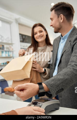 Adult woman and man using smart watch, paying for stuff Stock Photo