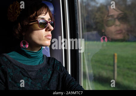 Girl traveling in train with reflection in window Stock Photo