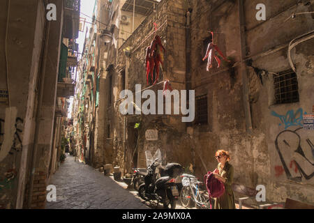 Good luck charms hanging above a narrow lane near the Pulcinella statue in Naples, Italy. Stock Photo