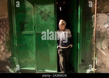 A man standing in a doorway looking down a street Stock Photo