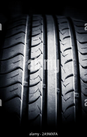 Close up of car tyre tread on the road on a bright day