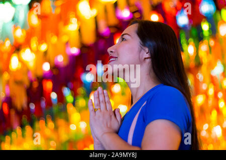 Portrait of Asian woman holding a traditional paper lantern during Yi peng (or Yee peng) festival in Thapae Gate Chiangmai Stock Photo