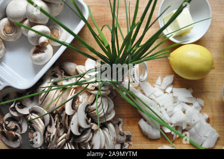Chives from above with sliced mushrooms and onions on a wooden board Stock Photo