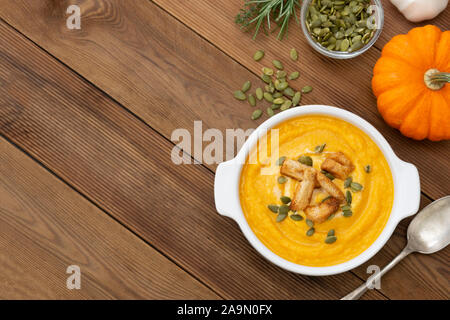 Creamy carrot soup, autumn foods. Spicy, roasted vegetable soup in bowl. Copy space. Stock Photo