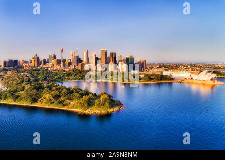 Sea route arrival to Sydney city on shores of beautiful Sydney harbour with major architecture Australian landmarks on a clean sunny morning - aerial Stock Photo