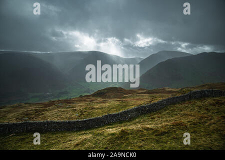 Sun breaking through rainy clouds over Kirkstone Pass, view from the top of Gale Crag in Lake District, UK Stock Photo