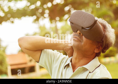 Senior man using VR google glass for exercise, Outdoor - Fitness concept using New technologies by elderly people - Old men stretching hands by Stock Photo