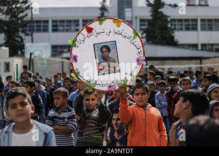 Gaza, Palestine. 16th Nov, 2019. Palestinian students hold pictures of the members of the Sawarka family who were killed during an Israeli air strike in Deir al-Balah.Israel said it targeted the Sawara family and killed seven people by mistake. Human rights groups have criticised previous IDF investigations into possible war crimes in the Gaza Strip. Credit: SOPA Images Limited/Alamy Live News Stock Photo