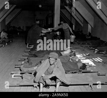 Original Caption: Sanitary care as provided by 121st Evacuation Hospital for some of 4000 persons at an abandoned Nazi airport near Neubau, Austria after their removal from Nazi concentration camps. The Evacuation Hospital not only provides medical care but directs sanitary work in the area. It arrived there May 9th. In one week the death rate dropped from 120 a day to about 25. Stock Photo