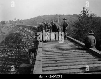 Industries of War - Lumbering - Track laying on line south near Beaver Creek, rail laying from hand car on bridge  ca. 1915-1920 Stock Photo