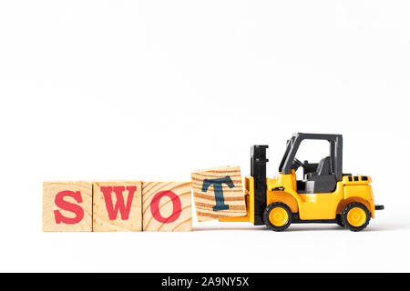 Toy forklift hold wood letter block t to complete word swot (abbreviation of strength, weakness, opportunities, threats) on white background Stock Photo