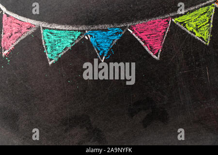 Colorful chalk drawing in hanging party flag shape on blackboard background Stock Photo
