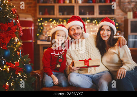 Loving family posing with Christmas gifts over decorated home background Stock Photo