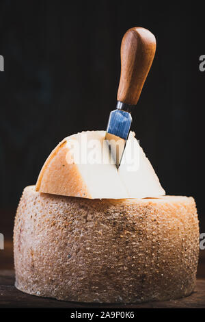 Piece Cut from Whole Matured Cheese Wheel. Traditional Food Produce. Stock Photo