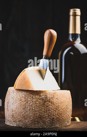 Piece Cut from Whole Matured Cheese Wheel. Traditional Food Produce. Stock Photo