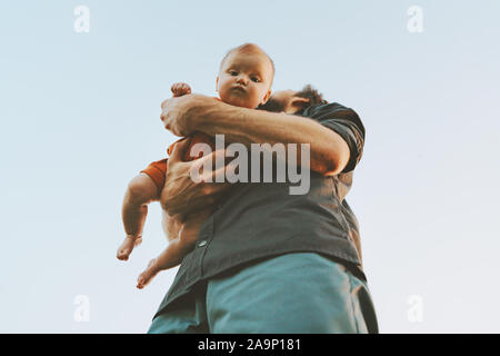 Father holding infant baby family lifestyle dad and child walking together parenthood childhood concept Fathers day holiday bottom view Stock Photo
