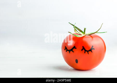sleepy face painted on tomato. Dream. Copyspace Stock Photo