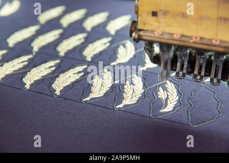 Close up with embroidery machine working on a blue matrix. Work in progress Stock Photo