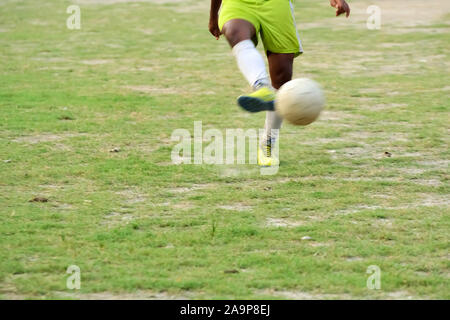 Soccer player is kicking ball during football practice in field Stock Photo