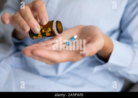 Elderly woman pouring pills from bottle on hand, closeup view Stock Photo